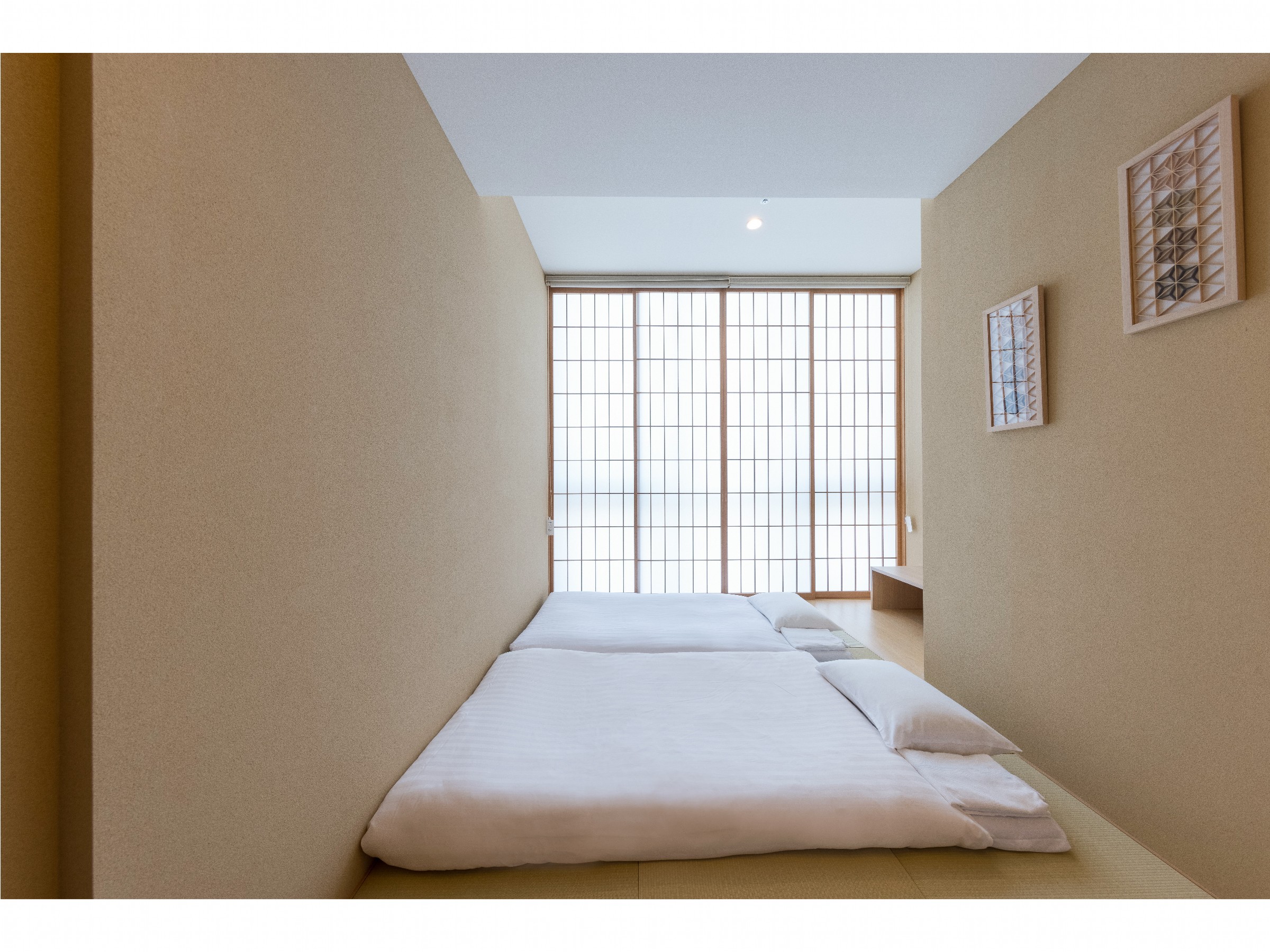プレミアムフォースのお部屋でございます。ベッド２つに加えて、畳の部屋にお布団を２枚ご用意しております。小さいお子様がベッドから落ちる心配なくお休みいただけます。
